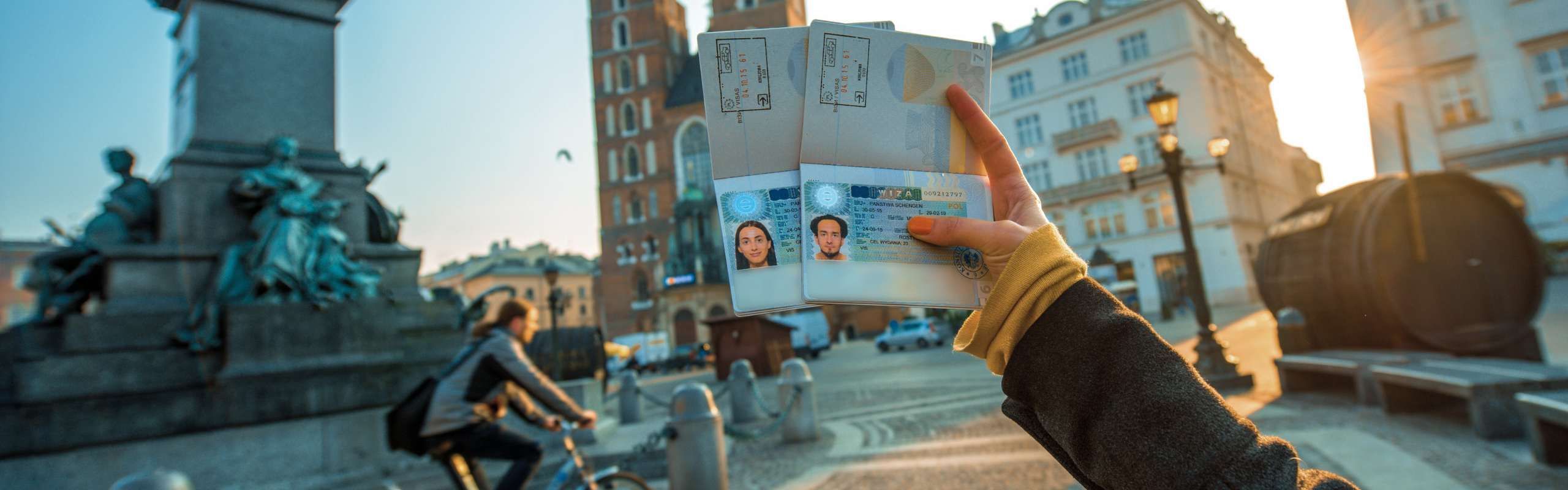 Female hands holding passports with visas over European city background