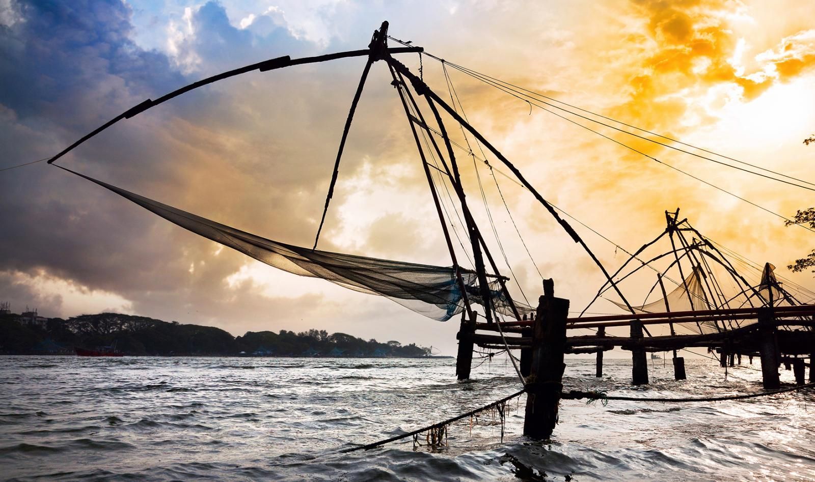 Fishing nets on pier overlooking water and sunrise