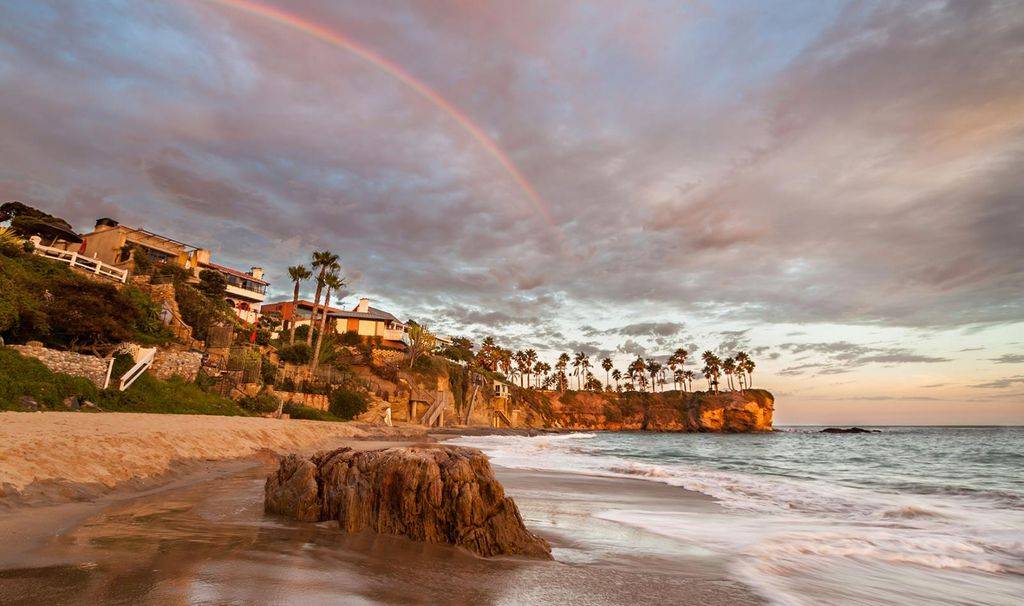 Irvine california coastline sandy beach with palm trees and rainbow