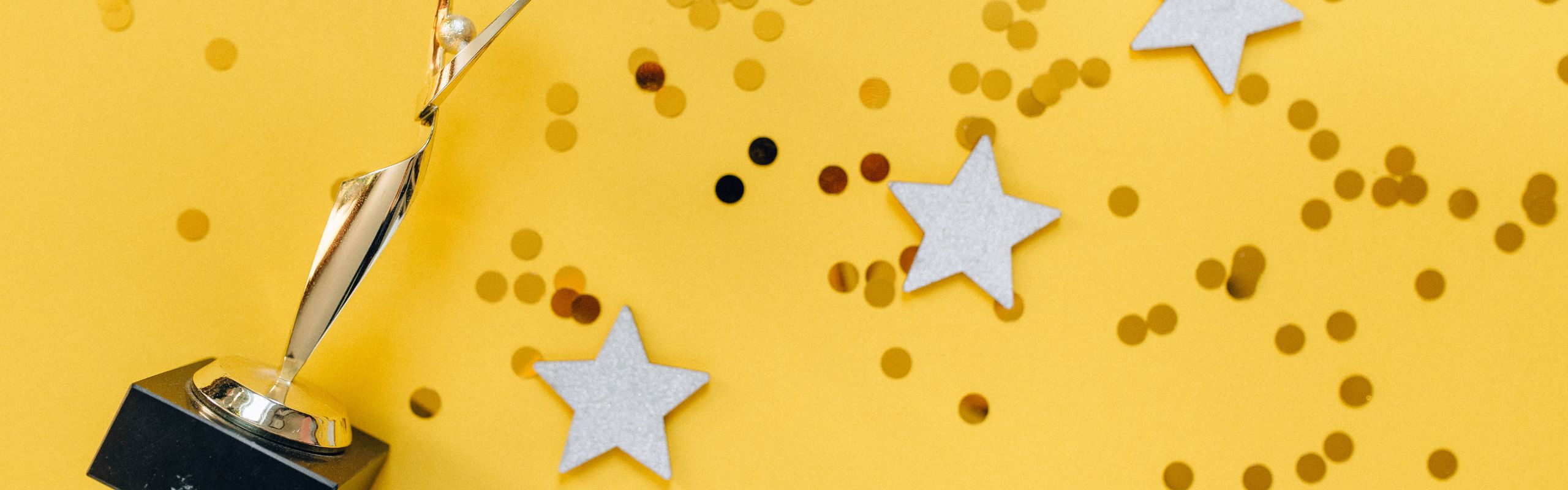 Image of a trophy with stars against a yellow background