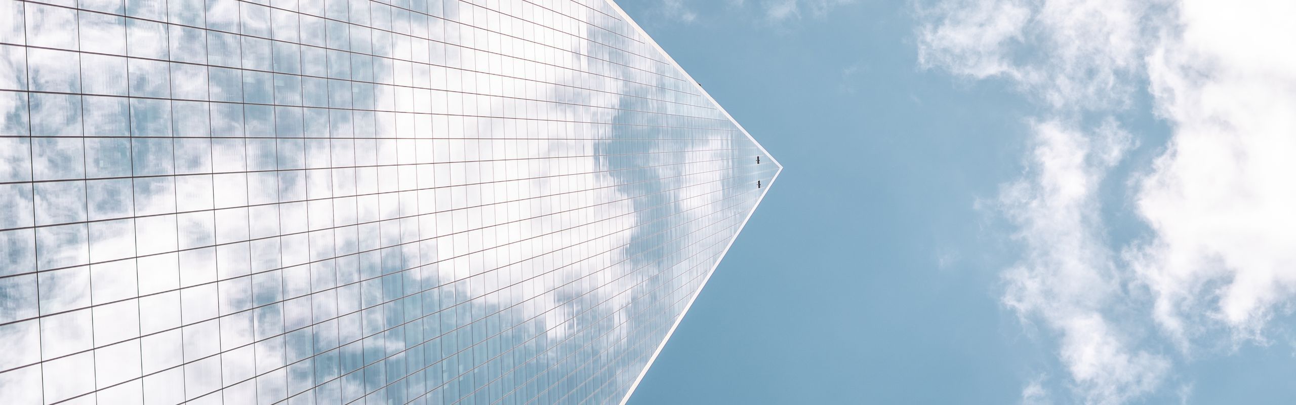 Skyscraper ascending into the sky creating a chevron outline against clouds